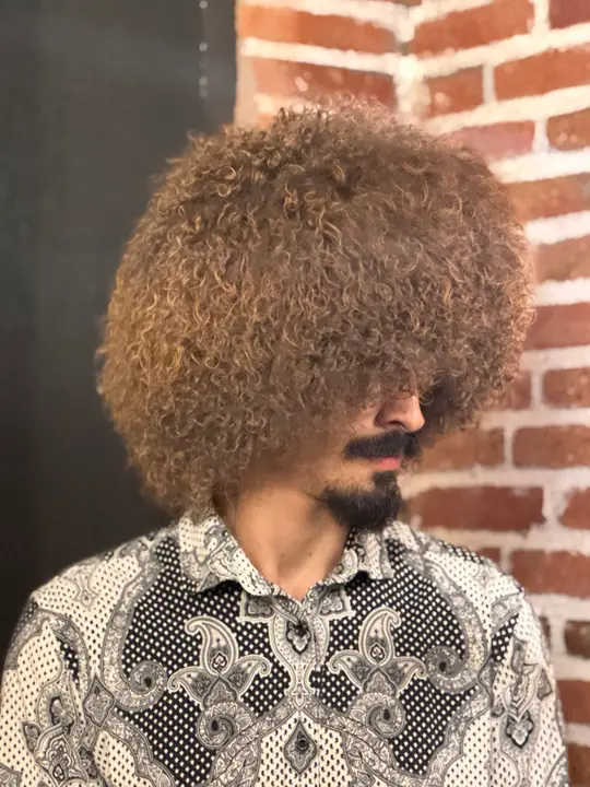 Goat Fur Papakha Special in profile: a large rounded shape of tight golden brown curls