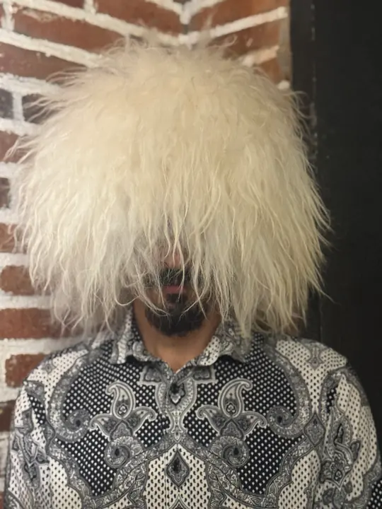 Very White Sheepskin Papakha: bright white sheepskin with long, straight, shaggy wool, worn, front view
