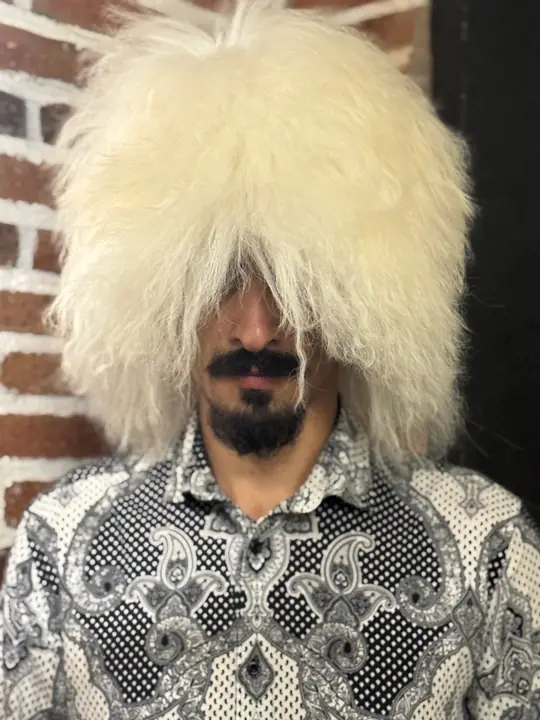 Very White Sheepskin Papakha, front view with the face partly visible under the long white fringe