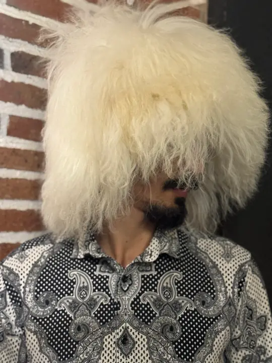 Very White Sheepskin Papakha, three-quarter view looking down: a full, square-cut fall of straight white wool