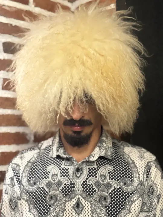 White Sheepskin Papakha, front view with the head turned slightly: dense cream-white wool, wavy at the ends